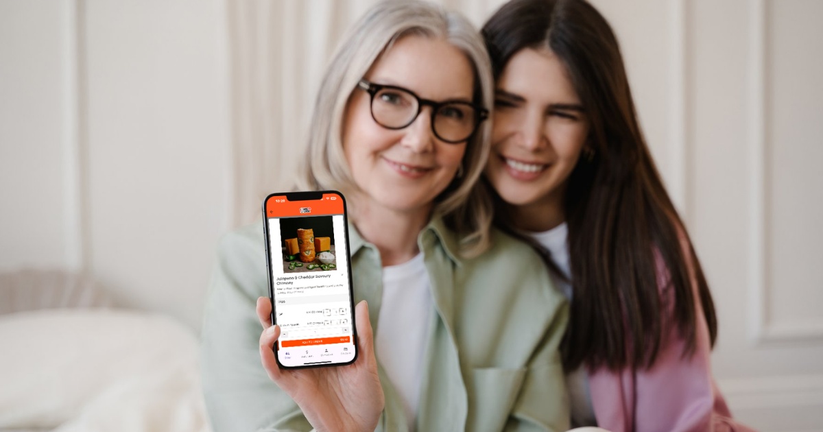 Picture of a happy customer placing a food order using the Dine Local platform illustrating the benefits of your own online ordering platform for restaurant owners. The words "Ditch the Middleman, Delight Your Customers" is overlayed along with the Dine Local logo.