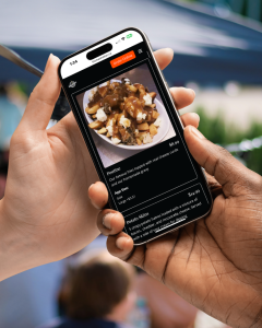 A person passing their mobile phone to another person showing a restaurant menu with a delicious looking photo showcasing the Dine Local restaurant website solution for independent restaurants.